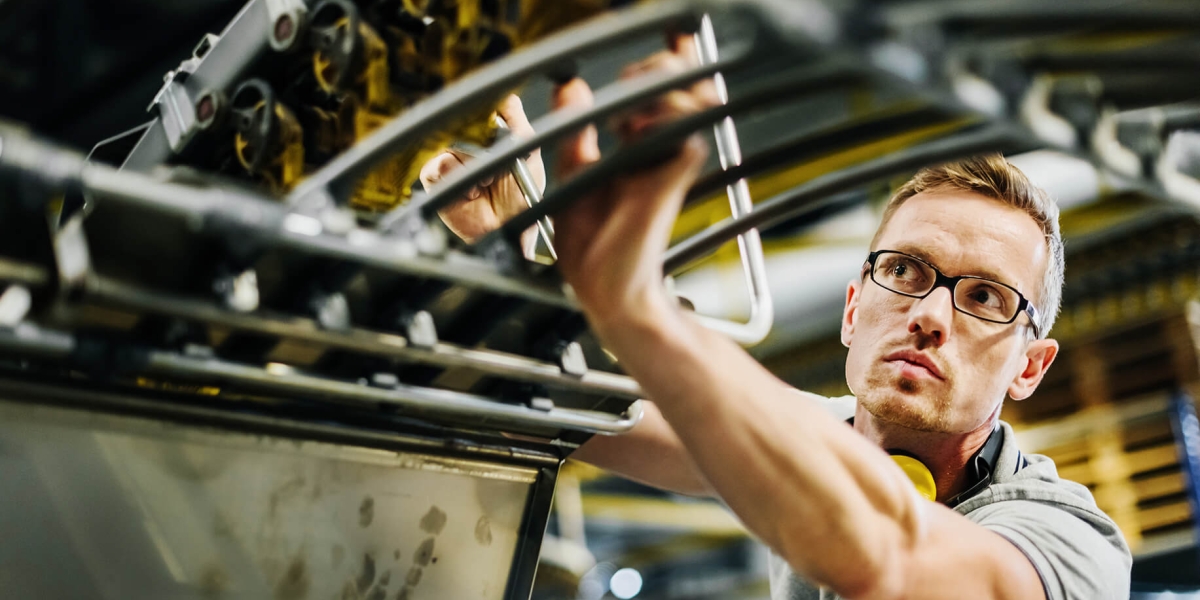Worker Checking Machine Parts of a Conveyor